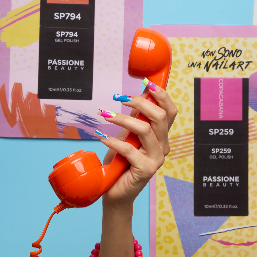 Mano con nail art a onde multicolore su smalto semipermanente gel neon, flaconi gel polish Passione Beauty e cornetta telefono su sfondo colorato