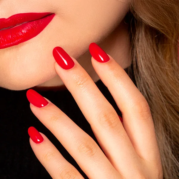 Passione Beauty bright red glossy gel polish on almond-shaped nails, professional manicure for nail artists