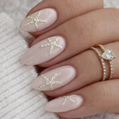 unghie nude color sabbia con stelle marine